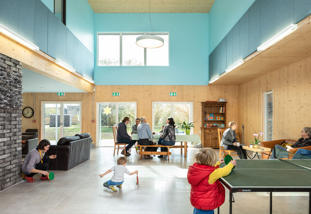 Image of Marmalade Lane Common House with people chatting and children playing table tennis